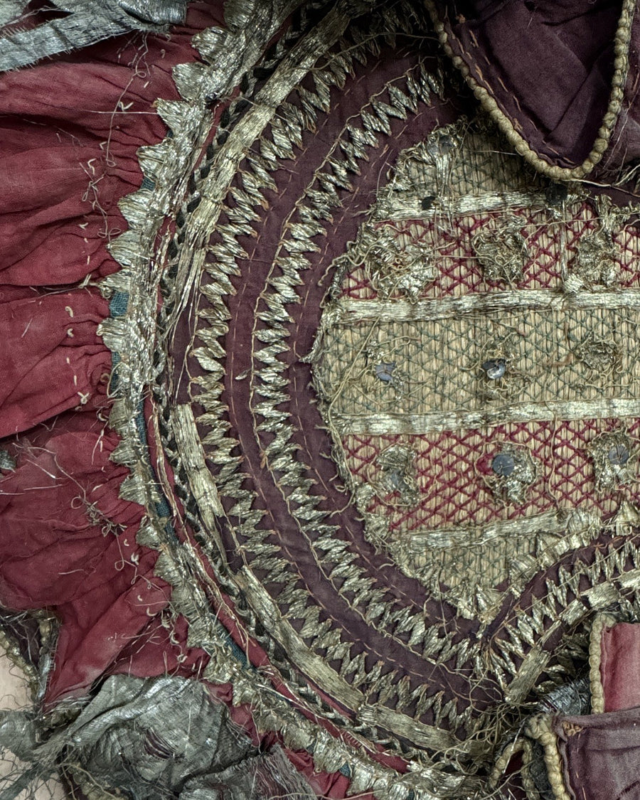 An embroidered medallion worked in concentric rings of metal thread